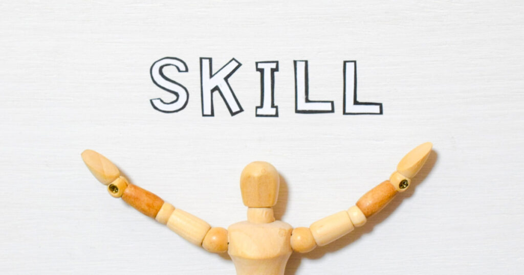 スキルの文字と両手を広げた木製マネキンの上半身